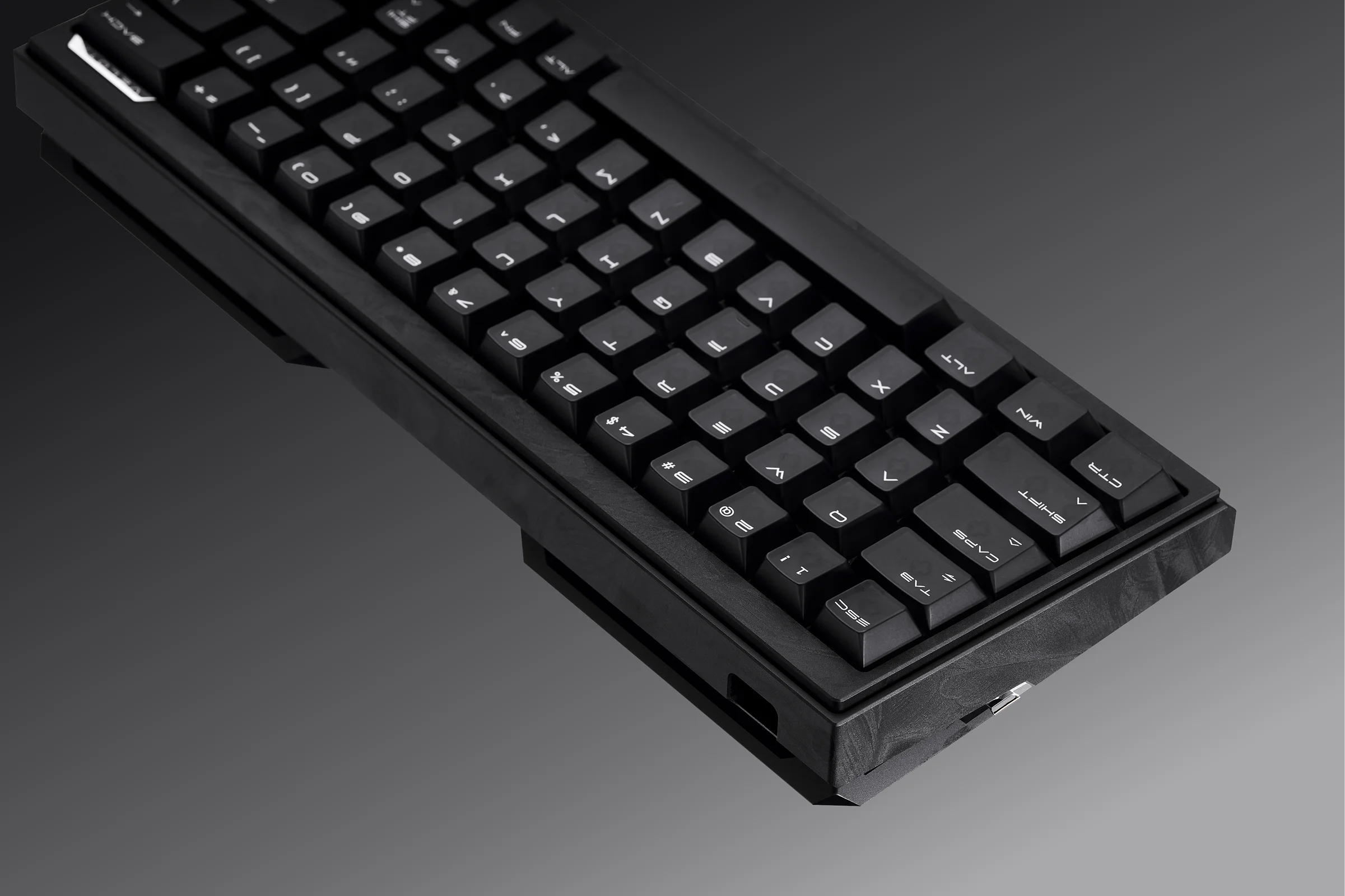 Close-up of black FUZZY 63 V2 keycaps and textured anodised aluminium case